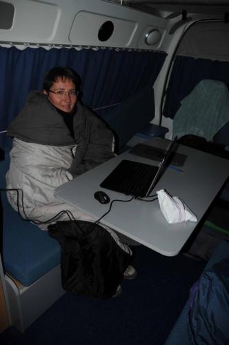 Carole, frigorifiée, emballée dans un duvet, le soir dans le camping-car