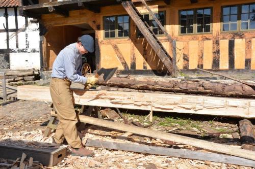 Le charpentier au travail avec la doloire.